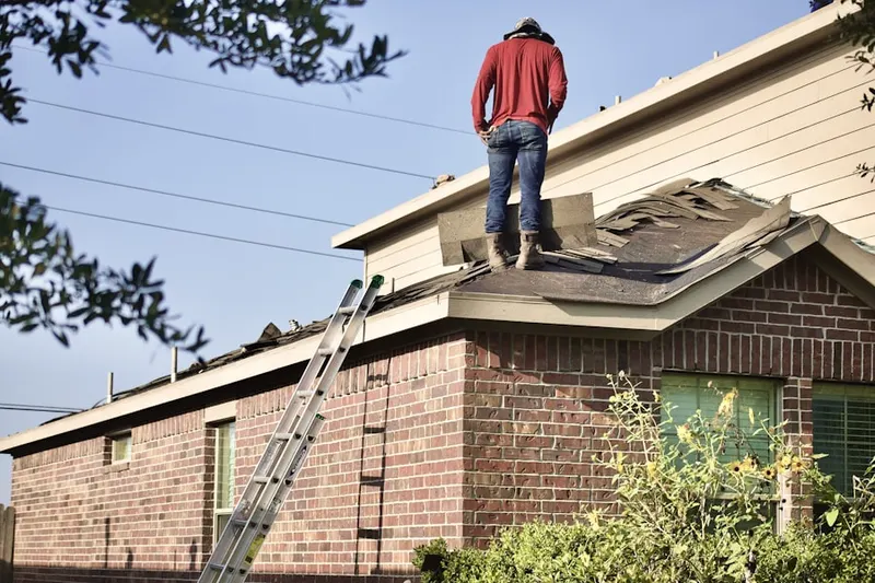 Professional roofer working on a residential roof in Harmarc Estates
